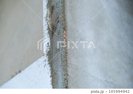 Installation of styrofoam insulation sheets on house facade wall for thermal protection. 105994942