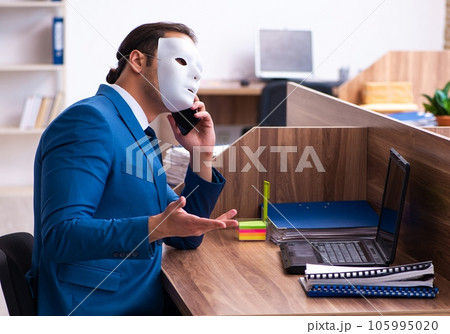 Young male employee wearing mask in the office Young male employee wearing mask in the office 105995020
