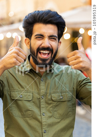 Young man shouting, celebrating success winning goal achievement good victory news in city street 105995319