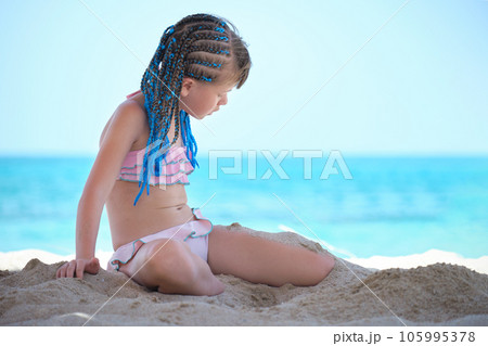 Cute happy child girl playing with sand on ocean beach during summer tropical vacations Cute happy child girl playing with sand on ocean beach during summer tropical vacations 105995378