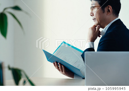 書類を見て悩むビジネスマン 105995945