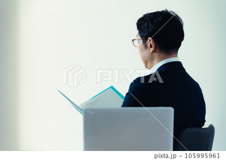 書類を見て悩むビジネスマン 105995961