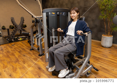 フィットネスジム　普段着でパーソナルトレーニングをする若い女性　コンビニジムイメージ 105996771