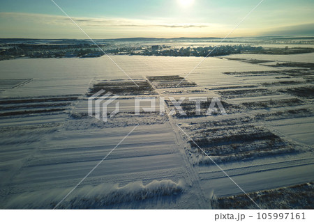 Aerial view of snow covered agricultural fields with barren surface in winter 105997161