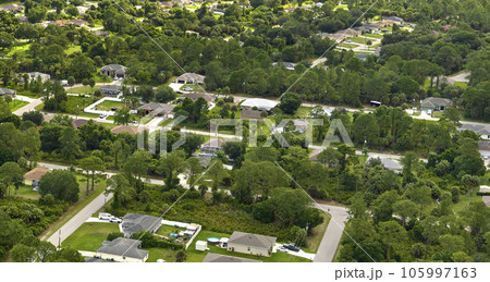 Aerial view of small town America suburban landscape with private homes between green palm trees in Florida quiet residential area 105997163