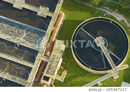 Aerial view of modern water cleaning facility at urban wastewater treatment plant. Purification process of removing undesirable chemicals, suspended solids and gases from contaminated liquid Aerial view of modern water cleaning facility at urban wastewater treatment plant. Purification process of removing undesirable chemicals, suspended solids and gases from contaminated liquid 105997227