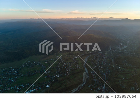 Aerial view from high altitude of residential houses in mountain village at sunset 105997664
