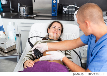 Woman getting ultrasound procedure for body contouring 105998302