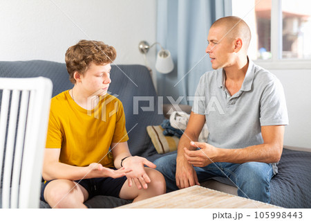 Dad and teenager son having conversation 105998443