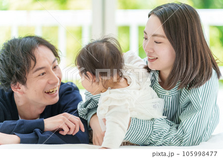 ベッドでリラックスする赤ちゃんと夫婦 105998477