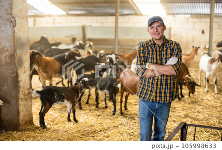 Portrait of confident male farm owner in goat pen Portrait of confident male farm owner in goat pen 105998633