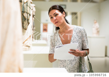 Woman standing in museum hall Woman standing in museum hall 105998716