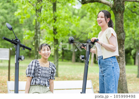 電動キックボードで会い、楽しく会話する若い女性|電動キックボードイメージ 電動キックボードで会い、楽しく会話する若い女性|電動キックボードイメージ 105999498
