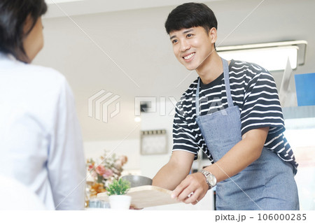 Waiter serving a cup of coffee to customer. 106000285