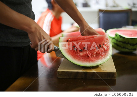 スイカを切り分ける男性 106000503