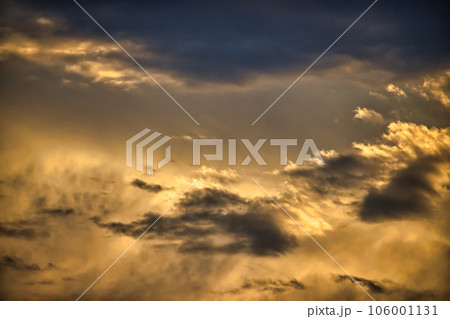 Sun casting long shadows and warm golden hue over clouds 106001131