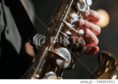 Saxophonist, jazz, blues. Close-up of saxophone and male fingers Saxophonist, jazz, blues. Close-up of saxophone and male fingers 106001651