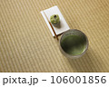 抹茶の入った抹茶茶碗と懐紙の上に和菓子 106001856