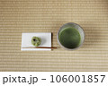 抹茶の入った抹茶茶碗と懐紙の上に和菓子 106001857