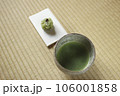 抹茶の入った抹茶茶碗と懐紙の上に和菓子 106001858