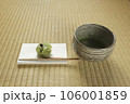 抹茶の入った抹茶茶碗と懐紙の上に和菓子 106001859