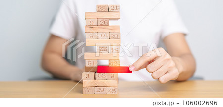 hand pulling wooden block tower on table. Business planning, Risk Management, Solution, leader, strategy, Crisis, falling Business, and Economic recession concept 106002696