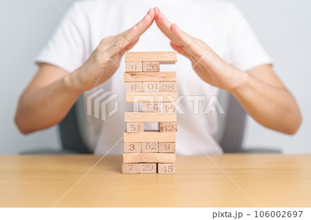 hand cover wooden block on the tower. Business planning, Risk Management, Solution, insurance and strategy Concepts 106002697