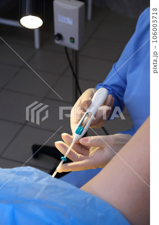Contraceptive IUD. Installation of a birth control system. The gynecologist installs an IUD. Gynecological chair. An intrauterine contraceptive device with a copper coil used for contraception. Contraceptive IUD. Installation of a birth control system. The gynecologist installs an IUD. Gynecological chair. An intrauterine contraceptive device with a copper coil used for contraception. 106003718
