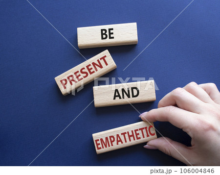 Be Present and Empathetic symbol. Concept words Be Present and Empathetic on wooden blocks. Businessman hand. Beautiful deep blue background. Business concept. Copy space 106004846