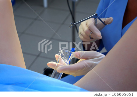 A gynecologist performs a cervical biopsy. Gynecological chair. A woman at the gynecologist for a check-up. 106005051
