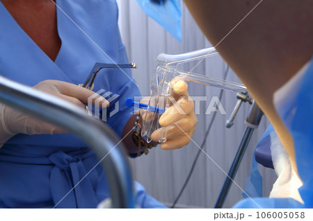 A gynecologist performs a cervical biopsy. Gynecological chair. A woman at the gynecologist for a check-up. A gynecologist performs a cervical biopsy. Gynecological chair. A woman at the gynecologist for a check-up. 106005058