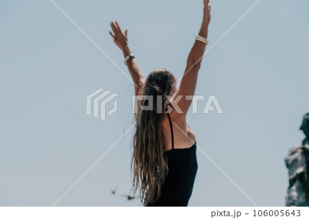 Woman summer travel sea. Happy tourist in hat enjoy taking picture outdoors for memories. Woman traveler posing on the beach at sea surrounded by volcanic mountains, sharing travel adventure journey Woman summer travel sea. Happy tourist in hat enjoy taking picture outdoors for memories. Woman traveler posing on the beach at sea surrounded by volcanic mountains, sharing travel adventure journey 106005643