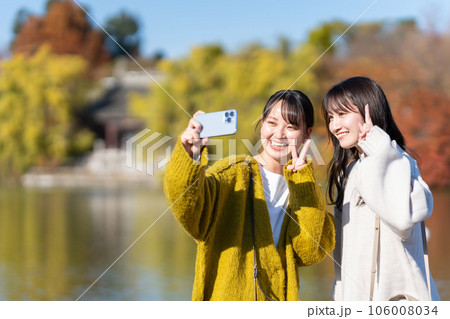 スマホで記念撮影をする女性 106008034