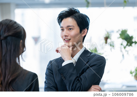 オフィスで話す新人ビジネスマン男女 オフィスで話す新人ビジネスマン男女 106009786