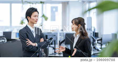 オフィスで話す新人ビジネスマン男女 オフィスで話す新人ビジネスマン男女 106009788