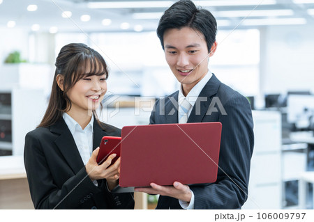 パソコンで仕事する新人ビジネスマン男女 106009797
