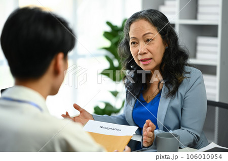 Middle age female human resource talking to a male candidate at the desk, interviewing a job applicant. Recruitment concept 106010954