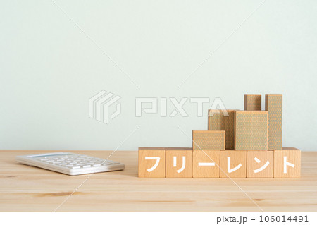 フリーレントと書かれたブロック、電卓、ミニチュアの建物 106014491