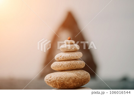 balanced rock pyramid stands tall on sea pebble beach. Selective focus highlights zen stones on the beach, evoking feelings of calm, harmony, and balance. Perfect for meditation or spa concepts. balanced rock pyramid stands tall on sea pebble beach. Selective focus highlights zen stones on the beach, evoking feelings of calm, harmony, and balance. Perfect for meditation or spa concepts. 106016544