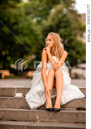 Woman city blanket. Morning in the big city. A blonde woman in a white blanket is enjoying in the city center. Photographed for social media Woman city blanket. Morning in the big city. A blonde woman in a white blanket is enjoying in the city center. Photographed for social media 106018277