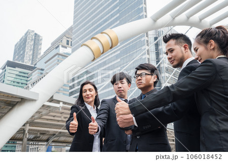 Group of multiethnic business team confident standing and showing thumbs up in urban 106018452