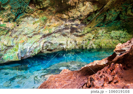 View of beautiful natural pool of crystal clear water formed in a rocky cave with stalagmites and stalagmites. Kuza cave in Zanzibar, Tanzania 106019108