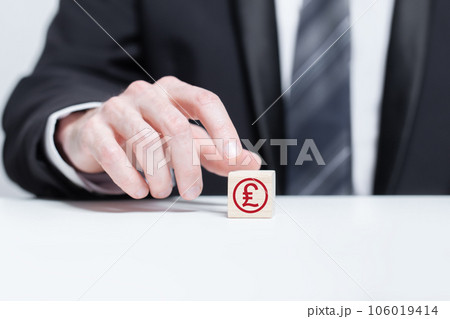 Wooden blocks with red currency pound sterling icon and red arrow down. Currency, business 106019414