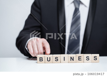 Wooden blocks with word business. Businessman pointing on cube.  106019417