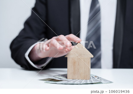 Two wooden houses and us money dollars under it. Byuing property, security, insurance concept Two wooden houses and us money dollars under it. Byuing property, security, insurance concept 106019436