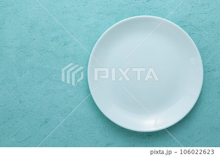 Empty Blue Ceramic Plate on Blue Cement background. Top view, copy space 106022623
