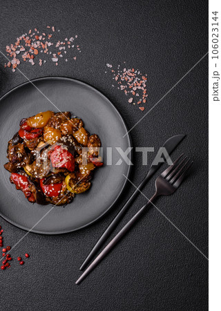 Delicious juicy fresh salad of baked eggplant, tomatoes, sweet peppers, sesame seeds 106023144
