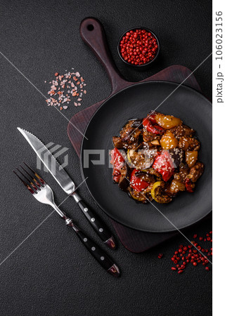Delicious juicy fresh salad of baked eggplant, tomatoes, sweet peppers, sesame seeds 106023156