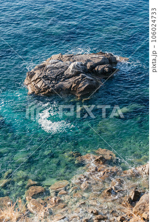 Waves on rocky beach, sea shore with waves crushing over the big rocks 106024733