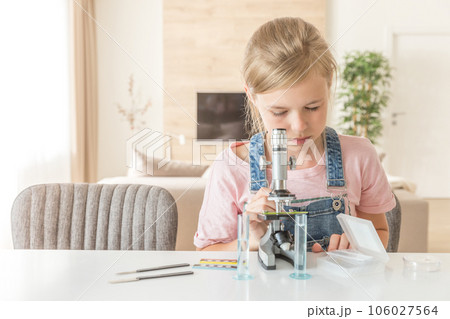 Girl learning chemistry playing with the microscope at home Girl learning chemistry playing with the microscope at home 106027564